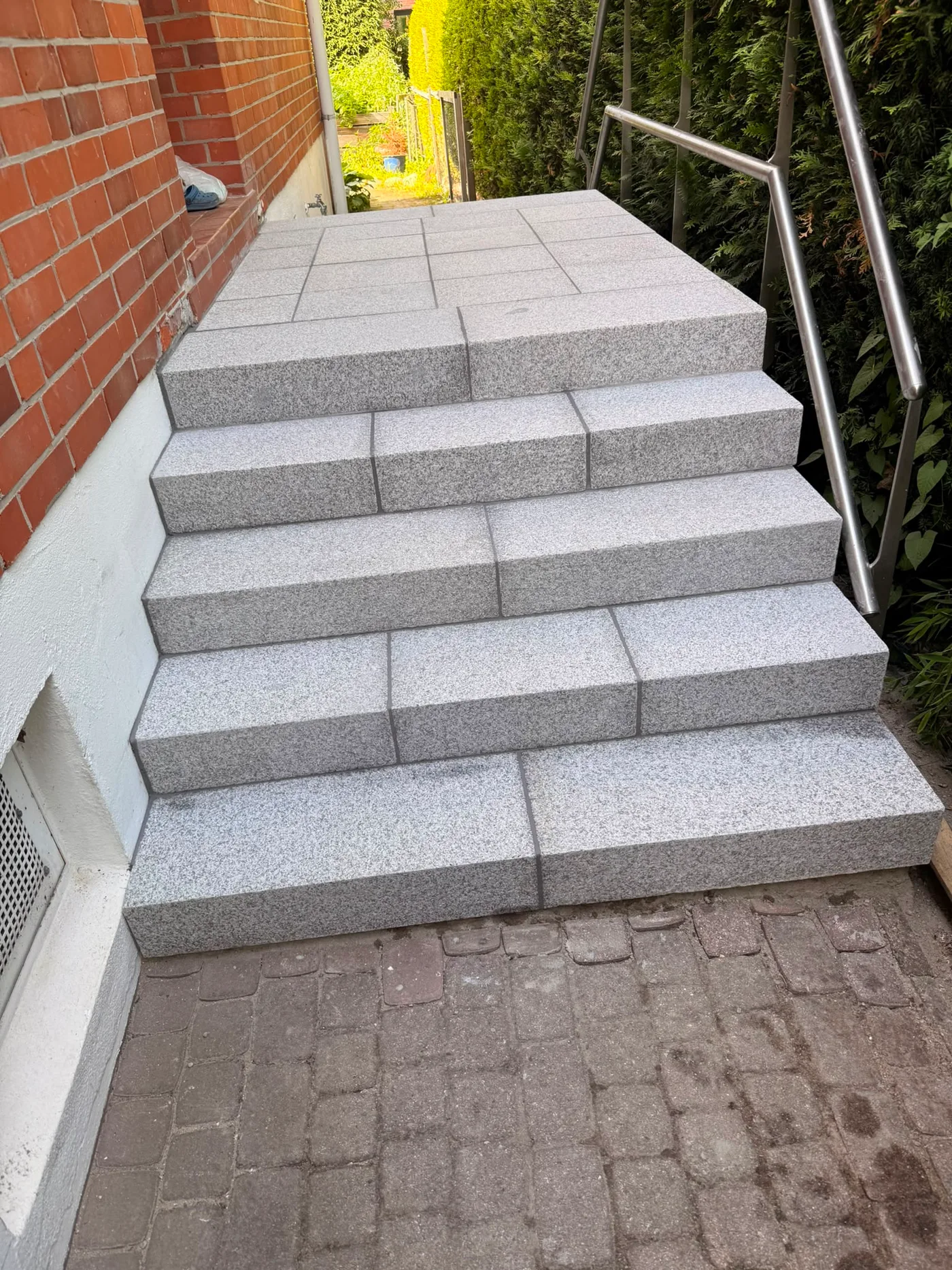 Treppeneingang – Nachher: neue Granittreppe von oben mit angrenzender Ziegelwand