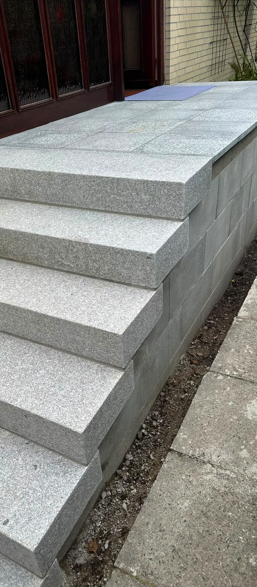 Treppeneingang – Nachher: Detailaufnahme der sauber verlegten Granit-Stufenkanten